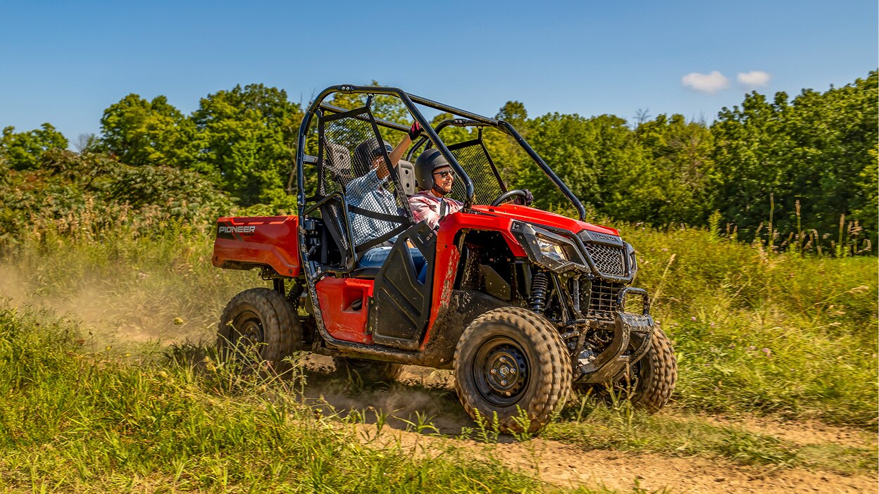 A Honda Pioneer 520 in a grassy field.