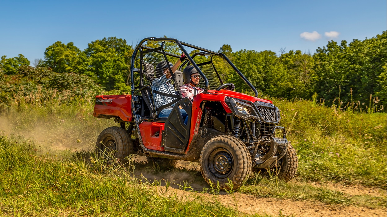 A Honda Pioneer 520 in a grassy field.