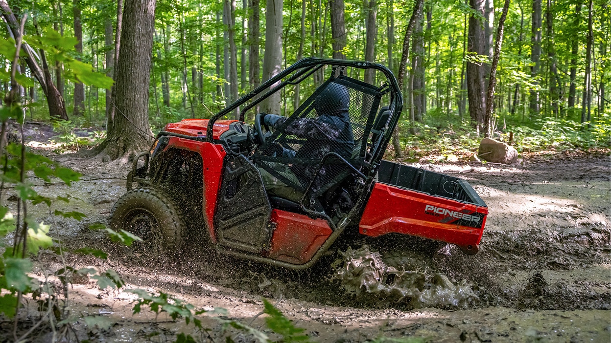 A Honda Pioneer 520 in a wooded area.