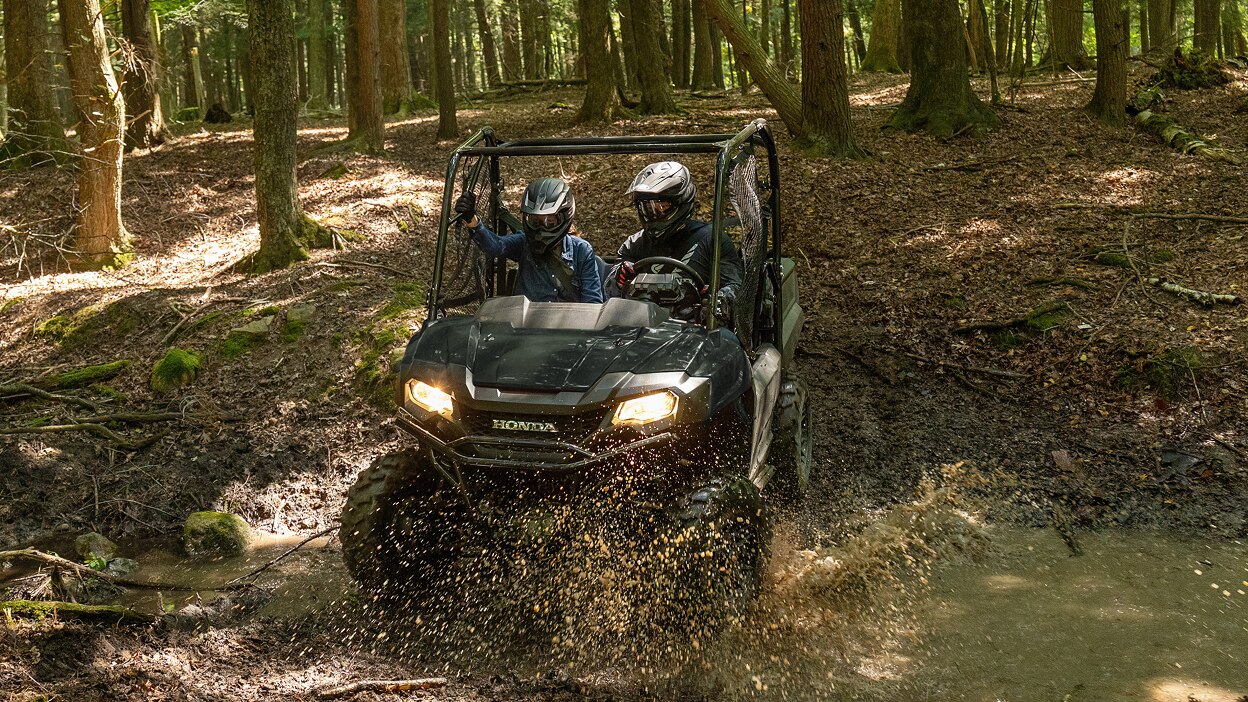 A Honda Pioneer 700 on a grassy dirt trail.