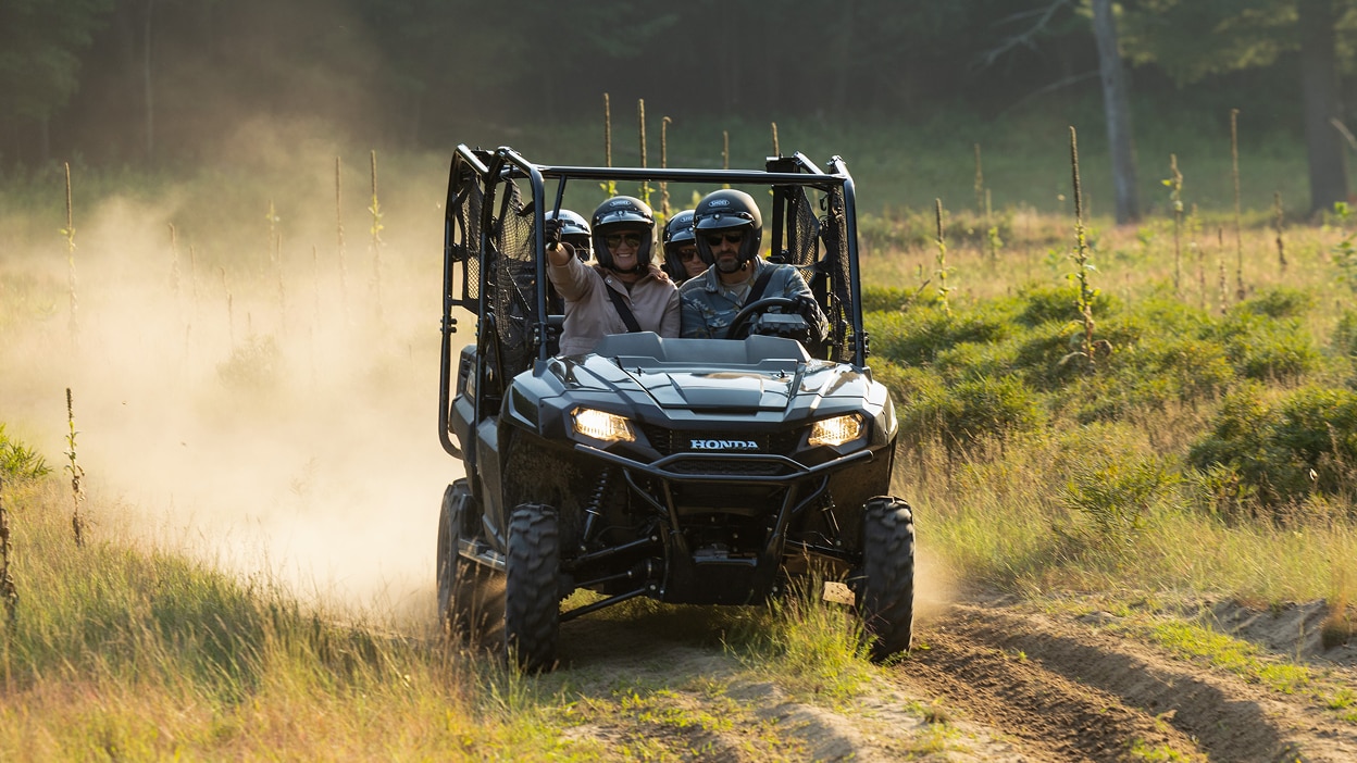 Un Honda Pioneer 700 éclaboussant dans la boue.